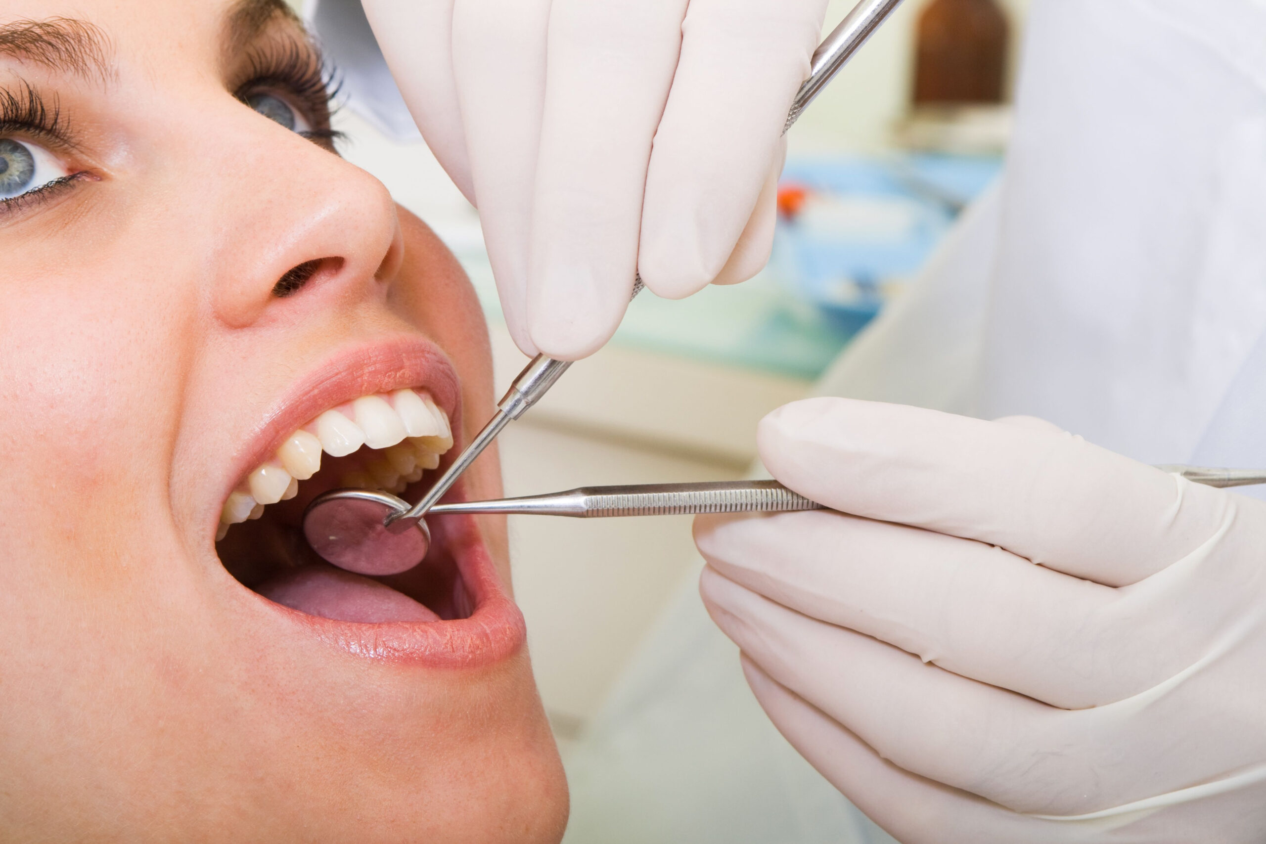 A doctor examines a patient’s teeth.